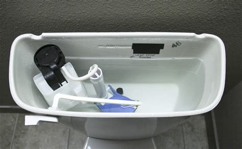 Remove the top of the tank. Pour two cups of distilled white vinegar into the tank and use a toilet brush to mix it into the water. Add one cup of baking soda and watch it fizz. After 10 minutes, scrub the inside of the tank with the toilet brush. Allow the mixture to sit for 20 minutes and flush the tank.